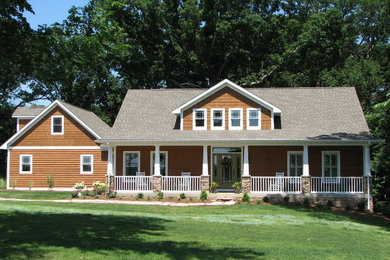 Diseño de fachada marrón de estilo de casa de campo con revestimiento de madera, tejado a dos aguas y tejado de teja de madera