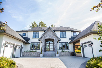 Large elegant blue three-story stone house exterior photo with a hip roof and a shingle roof