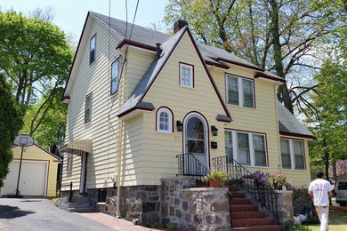 Inspiration for a mid-sized timeless yellow two-story exterior home remodel in Boston with a shingle roof