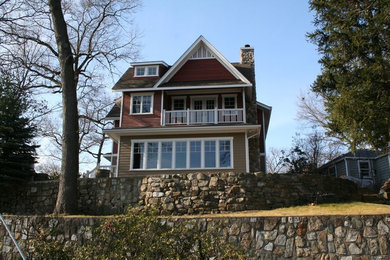 Foto de fachada de casa roja clásica grande de dos plantas con revestimiento de madera y tejado a dos aguas