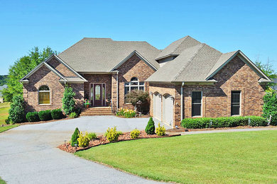 Example of a mid-sized classic brown two-story brick house exterior design in Orlando with a hip roof and a shingle roof