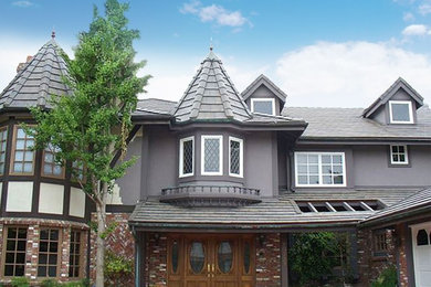 Large traditional gray two-story stucco house exterior idea in San Francisco with a shingle roof