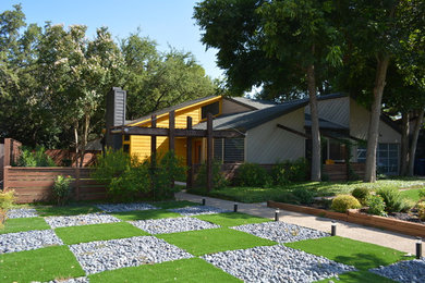Example of a mid-sized trendy yellow two-story wood exterior home design in Austin with a shed roof