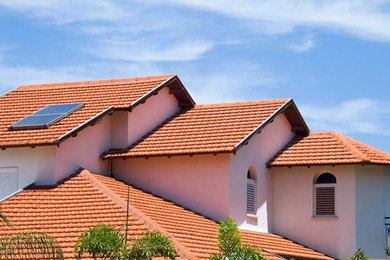 Ejemplo de fachada de casa blanca de tres plantas con tejado a dos aguas y tejado de teja de barro