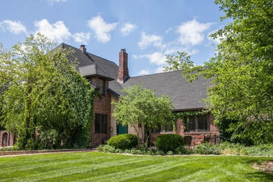 Example of a mid-sized classic red two-story brick exterior home design in Wichita with a shingle roof