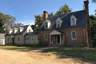Foto de fachada de casa beige clásica de tamaño medio de dos plantas con revestimiento de ladrillo, tejado a dos aguas y tejado de teja de barro