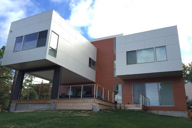 Large modern multicolored three-story mixed siding flat roof idea in Seattle