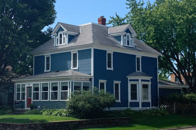 Inspiration for a large victorian blue three-story house exterior remodel in Minneapolis with a hip roof and a shingle roof