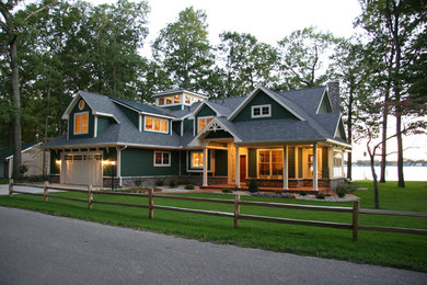 Esempio della facciata di una casa grande verde country a due piani con rivestimento in legno e tetto a padiglione