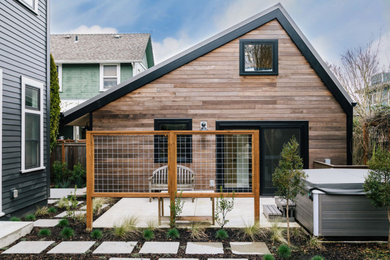 Diseño de fachada de casa marrón contemporánea pequeña de una planta con revestimiento de madera, tejado a dos aguas y tejado de metal