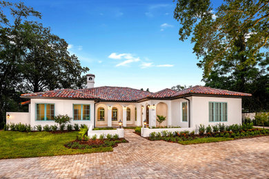 Example of a large tuscan white one-story stucco house exterior design in Orlando with a hip roof and a tile roof
