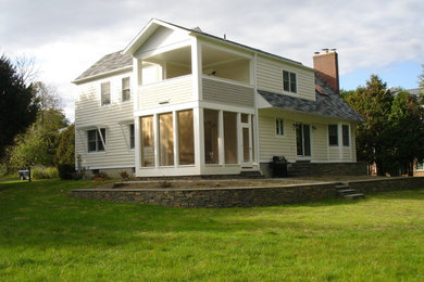 Inspiration for a large transitional yellow two-story wood exterior home remodel in New York