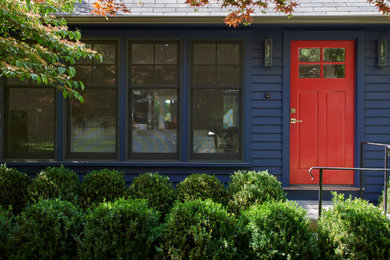 Diseño de fachada de casa azul clásica renovada de tamaño medio de una planta con revestimiento de madera
