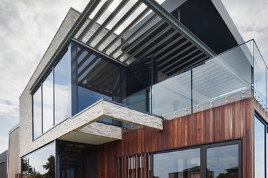 Aménagement d'une grande façade de maison contemporaine en bois à un étage avec un toit plat et un toit en métal.
