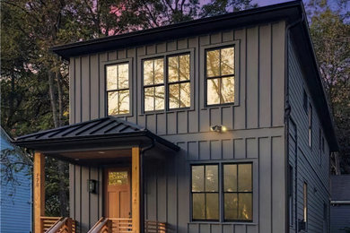 Large transitional black two-story house exterior idea in Atlanta with a clipped gable roof, a metal roof and a black roof