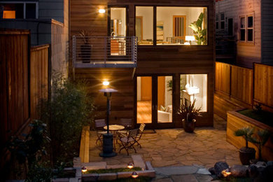 Idée de décoration pour une façade de maison minimaliste en bois de taille moyenne et à un étage avec un toit plat.