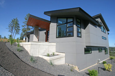 Imagen de fachada de casa gris contemporánea de tamaño medio de una planta con revestimiento de aglomerado de cemento, tejado de un solo tendido y tejado de metal