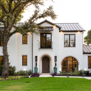 Zweistöckiges, Weißes, Graues Mediterranes Einfamilienhaus mit Backsteinfassade, Satteldach und Blechdach in Dallas