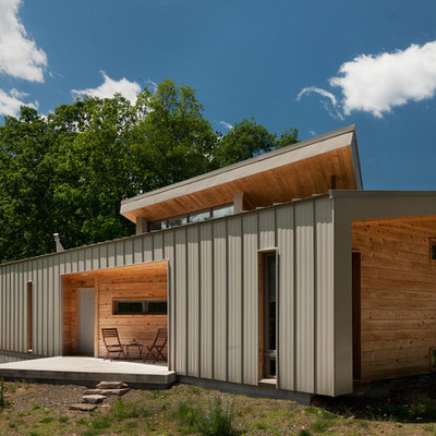Example of a small trendy brown one-story wood house exterior design in DC Metro with a shed roof and a metal roof