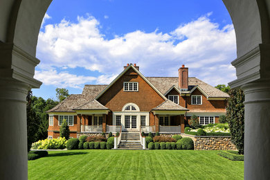 Пример оригинального дизайна: большой, двухэтажный, деревянный, коричневый дом в классическом стиле