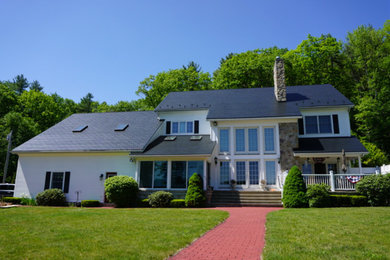 Modelo de fachada de casa blanca retro grande de dos plantas con tejado de metal y tejado a cuatro aguas