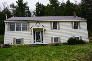 Ejemplo de fachada de casa beige tradicional de tamaño medio de dos plantas con tejado a cuatro aguas y tejado de metal