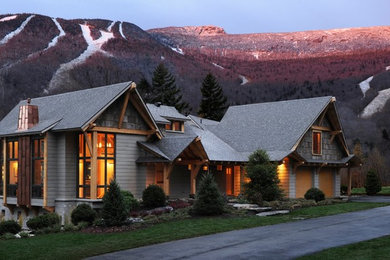 Diseño de fachada de casa gris rural grande de dos plantas con revestimiento de madera y tejado de teja de madera