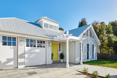 Diseño de fachada de casa blanca actual con tejado a dos aguas y tejado de metal