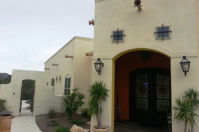 Ejemplo de fachada de casa beige de estilo americano de tamaño medio de una planta con revestimiento de adobe y tejado plano