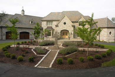 Imagen de fachada de casa beige clásica de dos plantas con revestimiento de piedra
