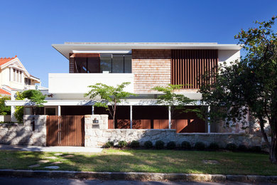 Idee per la facciata di una casa contemporanea a due piani con rivestimenti misti e tetto piano