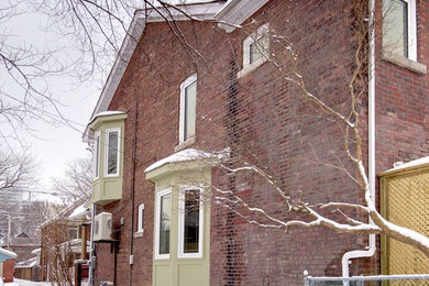 Small ornate red two-story brick exterior home photo in Toronto