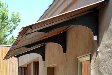 Diseño de fachada beige actual de tamaño medio de una planta con revestimiento de hormigón y tejado plano