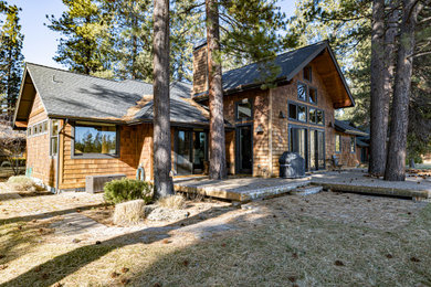 Diseño de fachada de casa marrón de estilo americano de tamaño medio de dos plantas con revestimiento de madera, tejado a dos aguas y tejado de teja de madera