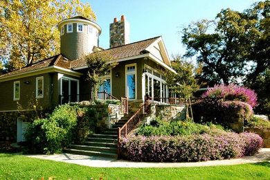 Modelo de fachada de casa verde de estilo americano de tamaño medio de dos plantas con revestimiento de madera, tejado a dos aguas y tejado de teja de madera