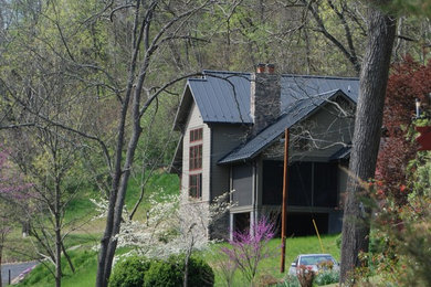 На фото: двухэтажный, бежевый частный загородный дом среднего размера в стиле кантри с облицовкой из ЦСП, двускатной крышей и металлической крышей с