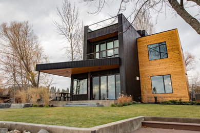 Exemple d'une grande façade de maison multicolore moderne à deux étages et plus avec un toit plat, un revêtement mixte et un toit en shingle.