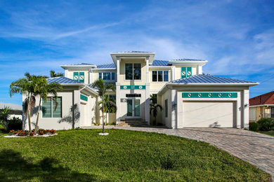 Large coastal multicolored two-story concrete fiberboard house exterior idea in Miami with a hip roof and a metal roof