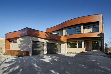 Großes, Zweistöckiges Modernes Einfamilienhaus mit Metallfassade, beiger Fassadenfarbe und Flachdach in Edmonton