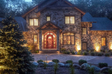 Inspiration for a huge timeless beige two-story stone house exterior remodel in Chicago with a shingle roof