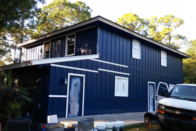 Imagen de fachada azul de estilo de casa de campo grande de dos plantas con revestimiento de madera y tejado de un solo tendido