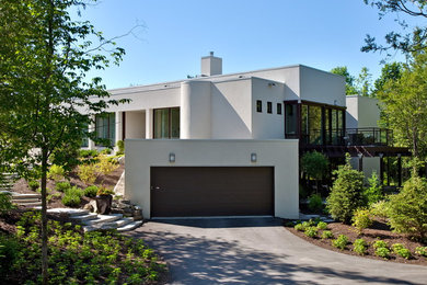 Example of a minimalist white one-story stucco flat roof design in Ottawa