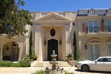 Huge elegant three-story stone exterior home photo in Los Angeles