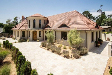 Diseño de fachada de casa beige mediterránea de tamaño medio de dos plantas con revestimiento de estuco, tejado a dos aguas y tejado de teja de madera