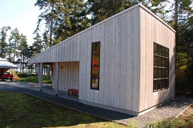 Ejemplo de fachada marrón contemporánea de tamaño medio de una planta con revestimiento de madera y tejado de un solo tendido
