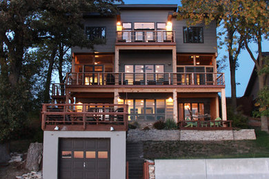Modelo de fachada de casa beige contemporánea de tamaño medio de tres plantas con revestimiento de madera, tejado plano y tejado de varios materiales