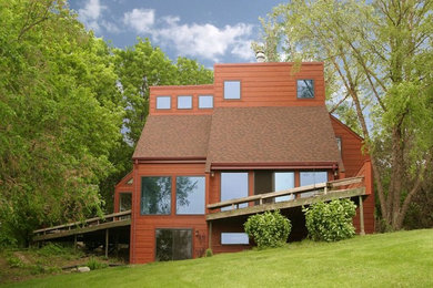 Diseño de fachada de casa roja retro de tamaño medio de tres plantas con revestimiento de madera y tejado plano