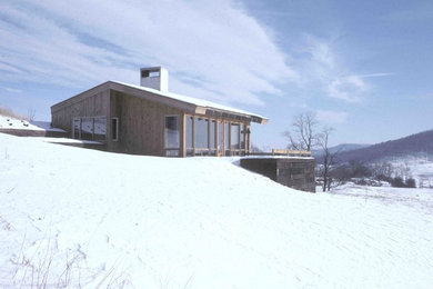 Cette photo montre une petite façade de maison grise tendance en bois à un étage.