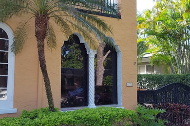 マイアミにある低価格のトラディショナルスタイルのおしゃれな家の外観 (漆喰サイディング、黄色い外壁) の写真
