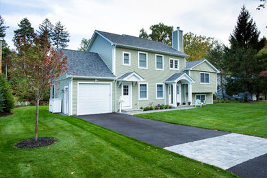 Example of a mid-sized classic green two-story vinyl exterior home design in New York with a shingle roof